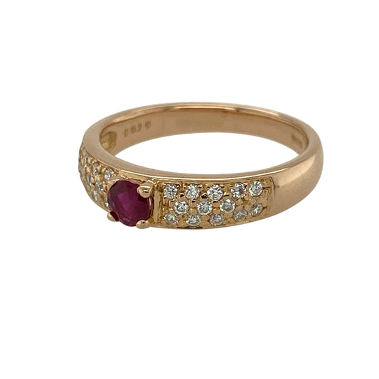 Add a touch of romantic colour and refined sparkle to your jewellery collection with this pre-owned 18ct rose gold diamond and ruby set band ring—an elegant piece perfect for everyday wear or special occasions.

Design: This ring features a central ruby measuring approximately 4mm in diameter, creating a rich and vibrant focal point, with multiple small diamonds set along half of the band for added brilliance and balance.