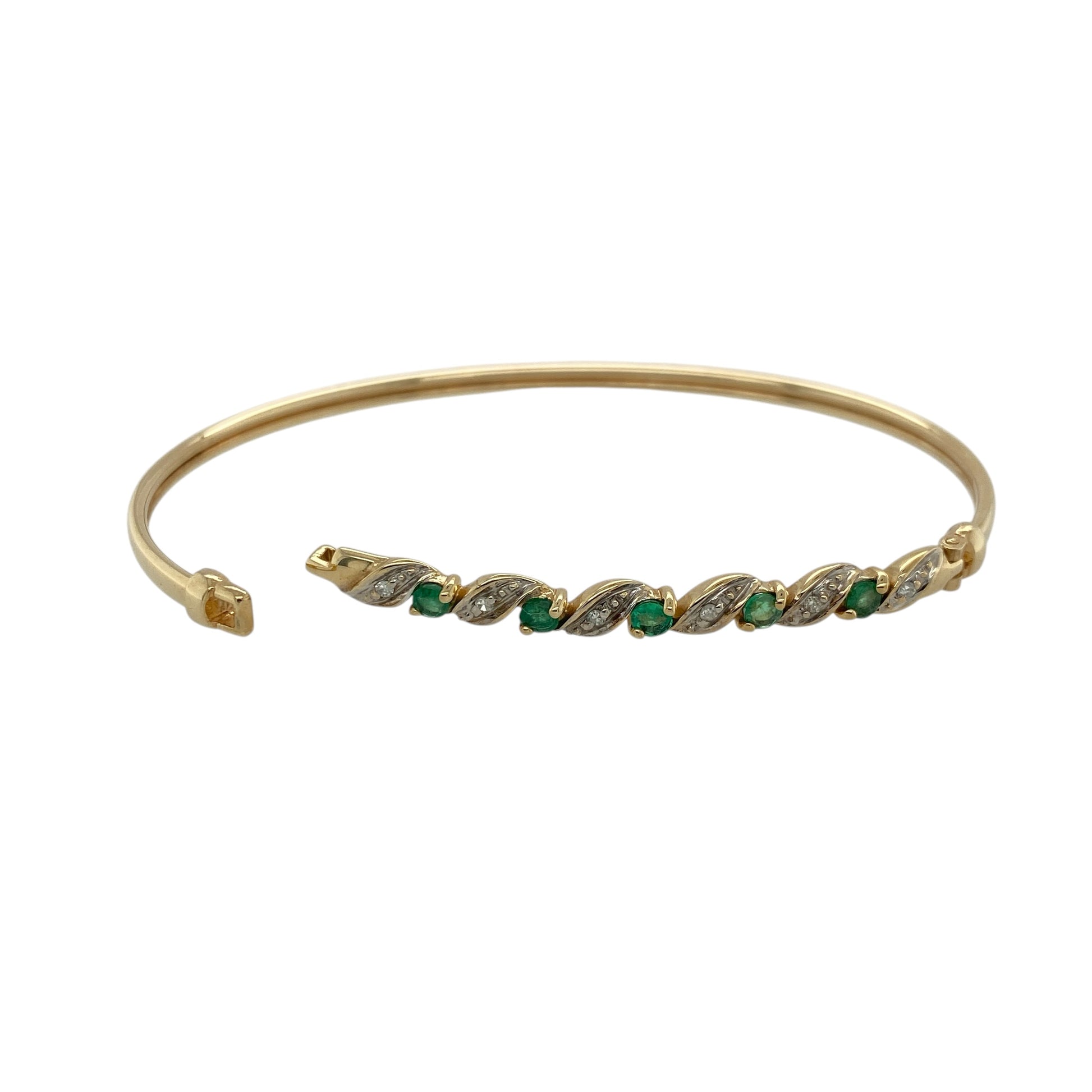 Add elegant colour and refined sparkle to your jewellery collection with this pre-owned 9ct yellow gold diamond and emerald set bangle—an eye-catching piece perfect for everyday wear or special occasions.

Design: This bangle features a classic circular design set with vibrant emerald gemstones, each measuring approximately 3mm in diameter, with small white gold set diamonds placed in between for added brilliance and contrast.