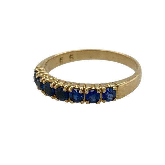 Add a touch of rich colour and timeless elegance to your jewellery collection with this pre-owned 18ct yellow gold sapphire set band ring—an understated yet eye-catching piece perfect for everyday wear.

Design: This band ring features seven round sapphire gemstones, each measuring approximately 2.5mm in diameter, arranged in a neat and balanced row across the front for a classic and refined look.