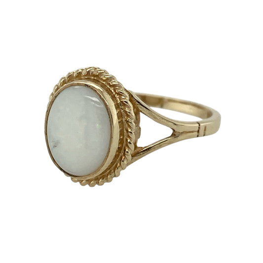 Add a soft shimmer of colour and classic detailing to your jewellery collection with this pre-owned 9ct yellow gold opalique set oval ring—an elegant and eye-catching piece perfect for everyday wear or special occasions.

Design: This ring features a central oval opalique stone measuring approximately 10mm by 8mm, surrounded by a decorative rope detail that adds texture and a vintage-inspired finish.