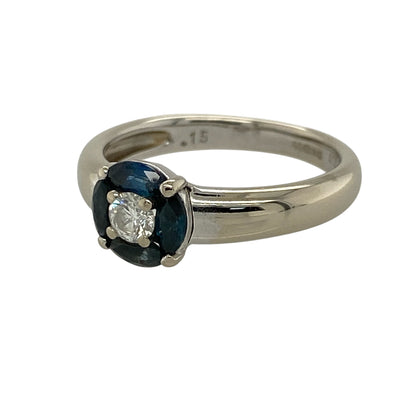 Add refined elegance and striking contrast to your jewellery collection with this pre-owned 18ct white gold diamond and sapphire set circle cluster ring—an eye-catching piece perfect for special occasions.

Design: This ring features an 8mm high circular cluster, centred with a sparkling 0.15ct diamond, surrounded by four marquise-cut sapphires that create a graceful and balanced floral-inspired design.