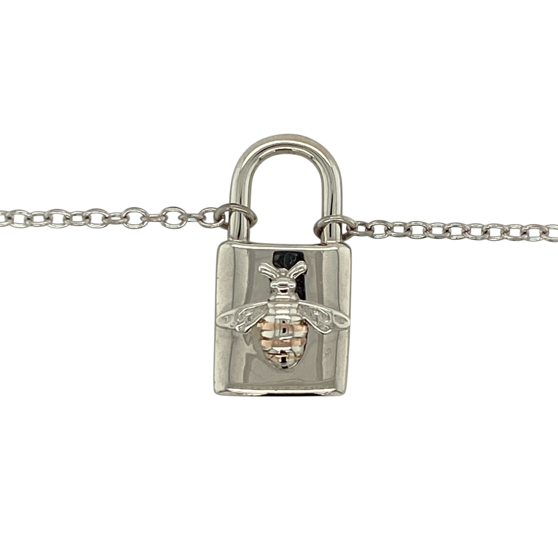 Add symbolic charm to your jewellery collection with this pre-owned 925 silver and 9ct rose gold padlock pendant necklace, featuring a delicate honey bee motif—perfect for everyday wear or meaningful gifting.

Design: The pendant is styled as a classic padlock adorned with a detailed honey bee, symbolising community, resilience, and harmony, with fine detailing that adds character and charm.