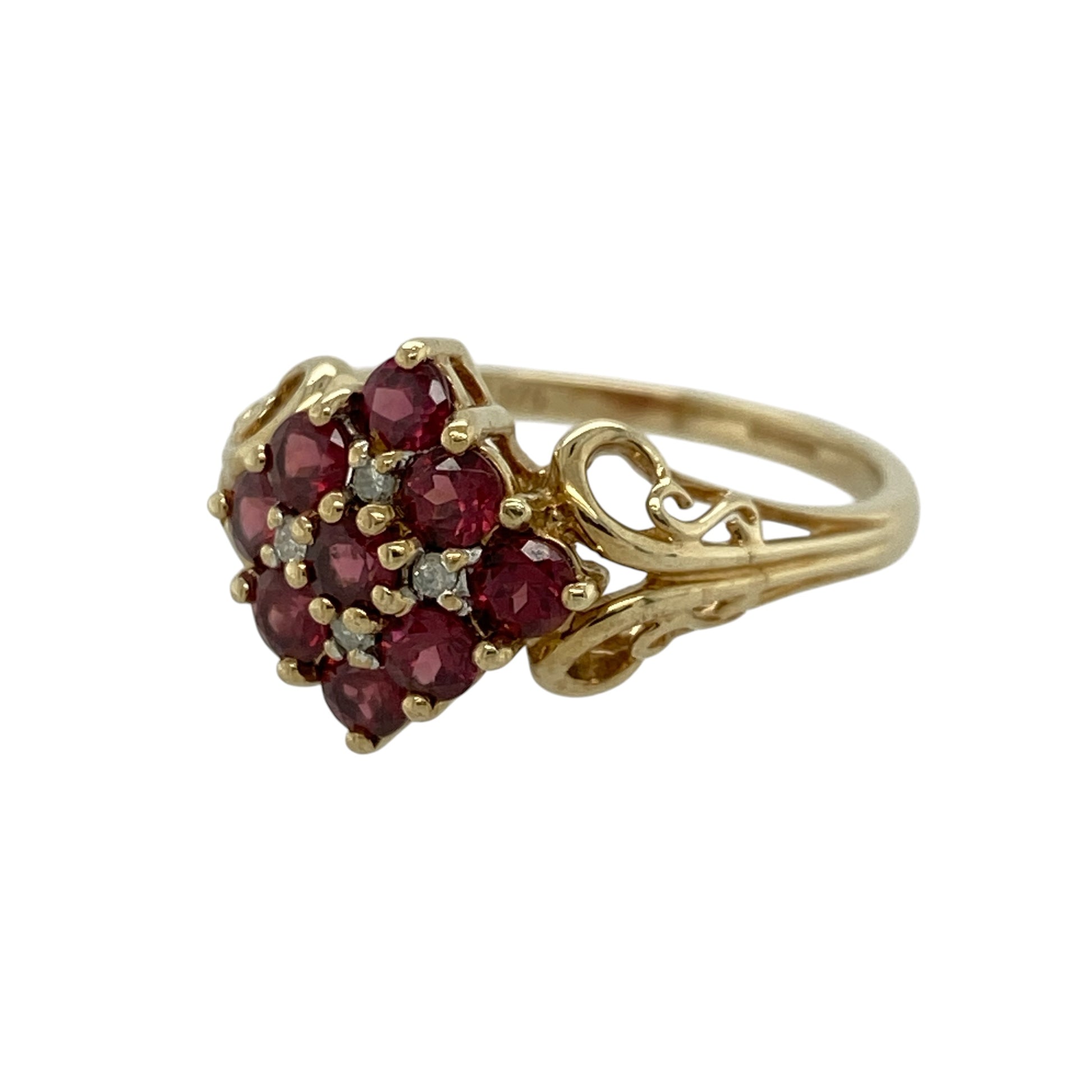 Add rich colour and classic elegance to your jewellery collection with this pre-owned 9ct yellow gold diamond and ruby cluster ring, featuring a bold floral-inspired design—perfect for special occasions or standout everyday wear.

Design: The ring features a cluster of nine round rubies, each approximately 3mm, arranged to create a striking and vibrant focal point, with small diamonds set in between adding extra sparkle and contrast.