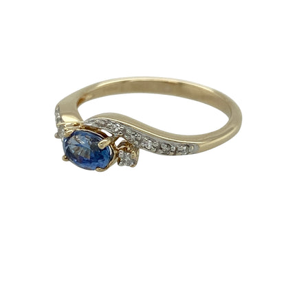 Add graceful movement and classic sparkle to your jewellery collection with this pre-owned 9ct yellow gold diamond and sapphire twist ring, featuring a flowing design and rich colour—perfect for everyday wear or special occasions.

Design: The ring showcases an oval sapphire measuring approximately 6mm by 4mm at its centre, with diamonds positioned on either side and continuing along the twist band above and below for added brilliance.