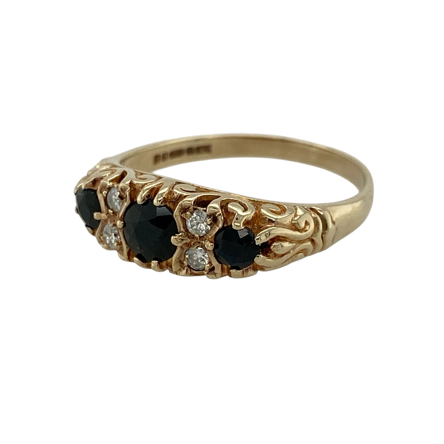Add timeless elegance and rich colour to your jewellery collection with this pre-owned 9ct yellow gold diamond and sapphire trilogy ring, featuring classic gemstones and refined sparkle—perfect for special occasions or everyday wear.

Design: The ring showcases three round sapphires, with the centre stone measuring approximately 4mm in diameter and the two side stones approximately 3mm each, complemented by two diamonds set between each sapphire for added brilliance.