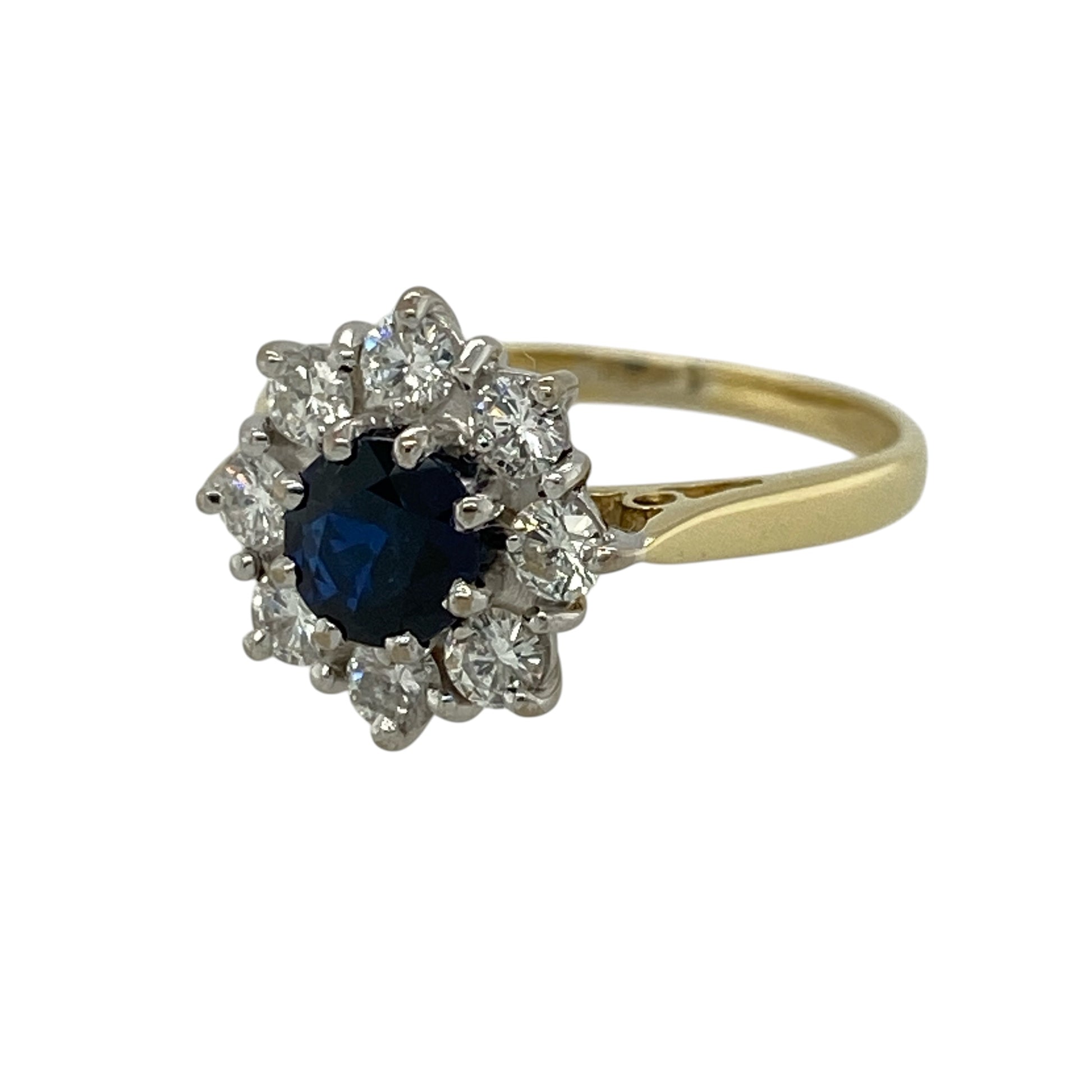 Add timeless elegance and floral-inspired charm to your jewellery collection with this pre-owned 18ct yellow gold diamond and sapphire cluster ring, featuring a classic design with rich colour and sparkle—perfect for special occasions or refined everyday wear.

Design: The ring features a round sapphire measuring approximately 5mm in diameter at its centre, surrounded by sparkling diamonds arranged in a flower-style cluster for a soft and eye-catching look.