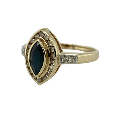 Add elegant sparkle and classic style to your jewellery collection with this pre-owned 9ct yellow gold diamond and sapphire marquise cluster ring, featuring a striking elongated design—perfect for special occasions or refined everyday wear.

Design: The ring showcases a marquise-cut sapphire measuring approximately 8mm by 4mm at its centre, surrounded by sparkling diamonds with additional diamond detailing along the shoulders for enhanced brilliance.