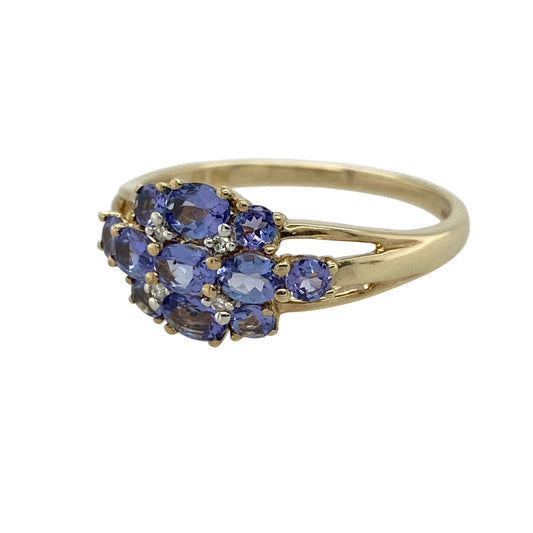 Add vibrant colour and elegant sparkle to your jewellery collection with this pre-owned 9ct yellow gold diamond and tanzanite cluster ring, featuring a beautifully detailed design—perfect for special occasions or refined everyday wear.

Design: The ring showcases a cluster of multiple oval and round tanzanite stones, creating a rich blend of violet-blue tones, with small diamonds set in between adding extra brilliance and contrast.