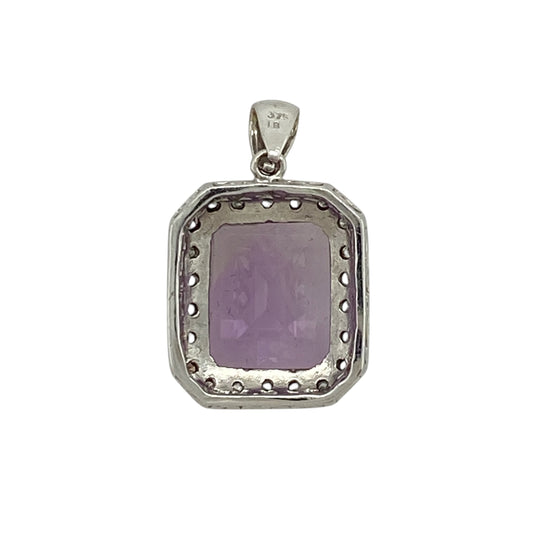 Add bold colour and refined sparkle to your jewellery collection with this pre-owned 9ct white gold diamond and amethyst pendant, featuring a striking centre stone and elegant surround—perfect for special occasions or statement everyday wear.

Design: The pendant showcases a rectangular amethyst measuring approximately 12mm by 10mm, surrounded by small diamonds that enhance its rich purple tones and create a classic cluster effect.
