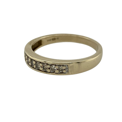 Add subtle sparkle to your jewellery collection with this pre-owned 9ct yellow gold diamond set band ring, featuring a classic and versatile design—perfect for everyday wear or stacking.

Design: The ring features a sleek band set with diamonds totalling approximately 0.15ct, offering a refined line of brilliance across the front.
Material: Made from 9ct yellow gold, the polished finish enhances the warm tone of the metal while complementing the sparkle of the diamonds.