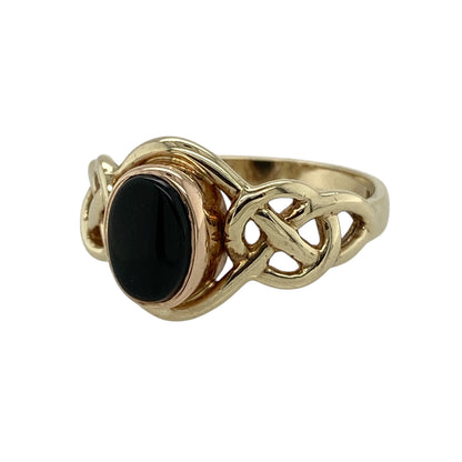 Bring heritage style and bold contrast to your collection with this pre-owned 9ct yellow and rose gold onyx set Clogau Celtic knot ring—a meaningful design rich in symbolism and timeless elegance.

Design: The ring features a 8mm by 6mm deep black onyx stone framed by an intricate Celtic knot design, blending warm yellow and rose gold tones in true Clogau style.
Material: Made from 9-carat yellow and rose gold, the polished finish enhances both the dark sheen of the onyx and the detailed knotwork.