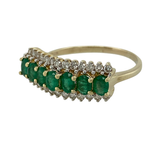 Add bold colour and refined sparkle to your jewellery collection with this pre-owned 14ct yellow gold diamond and emerald band ring, featuring a striking multi-row design—perfect for special occasions or statement everyday wear.

Design: The ring showcases a central row of oval emeralds measuring approximately 4mm by 3mm each, with rows of diamonds set above and below, creating a vibrant and eye-catching layered effect.