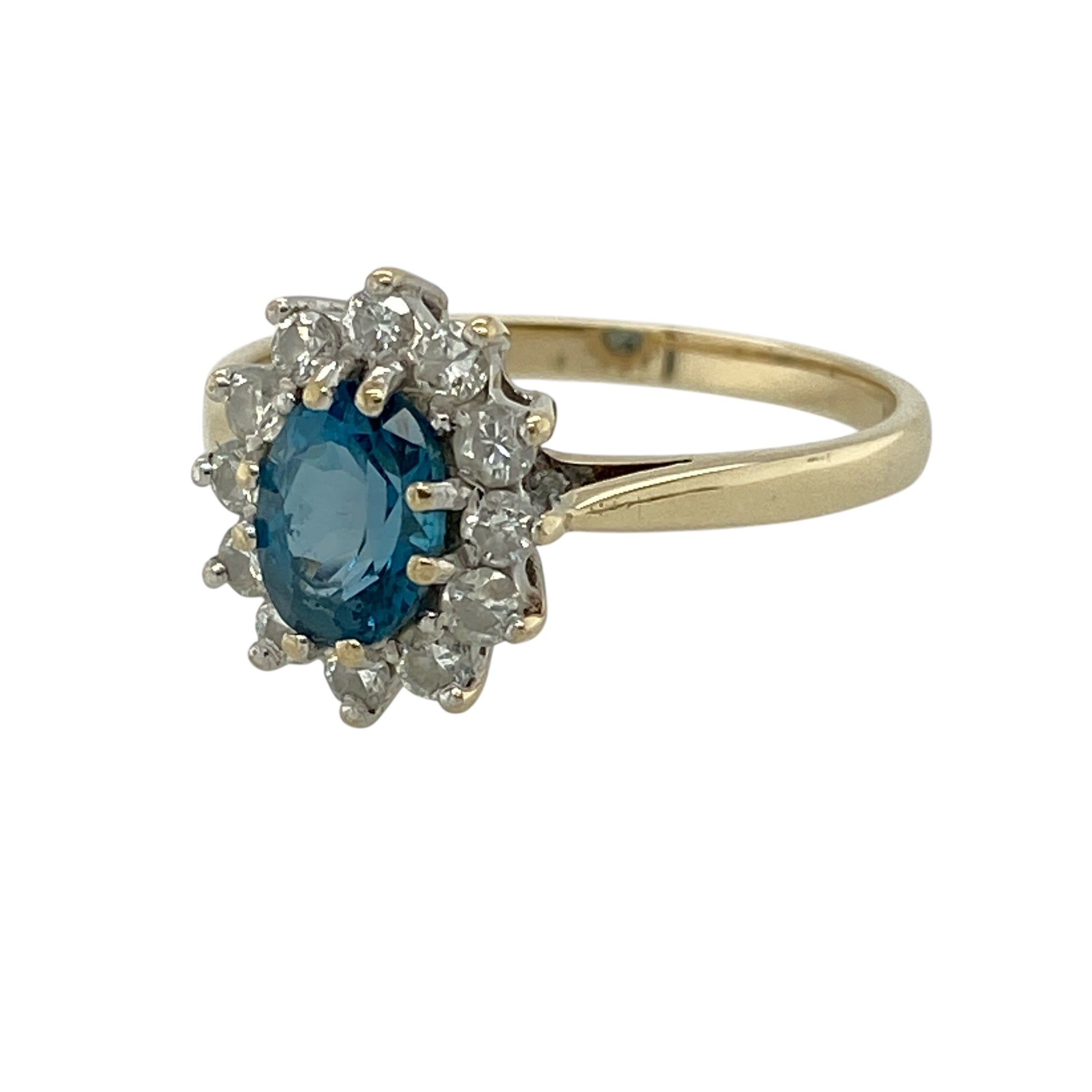 Add vibrant colour and elegant sparkle to your jewellery collection with this pre-owned 9ct yellow gold diamond and blue topaz cluster ring, featuring a classic design with a striking centre—perfect for special occasions or refined everyday wear.

Design: The ring showcases an oval blue topaz measuring approximately 7mm by 5mm at its centre, surrounded by sparkling diamonds that enhance its bright blue tone and create a timeless cluster effect.