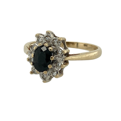 Add timeless elegance and floral-inspired charm to your jewellery collection with this pre-owned 9ct yellow gold diamond and sapphire cluster ring, featuring a classic design with refined sparkle—perfect for everyday wear or special occasions.

Design: The ring showcases an oval sapphire measuring approximately 6mm by 4mm at its centre, surrounded by sparkling diamonds arranged in a flower-style cluster for a soft and elegant look.