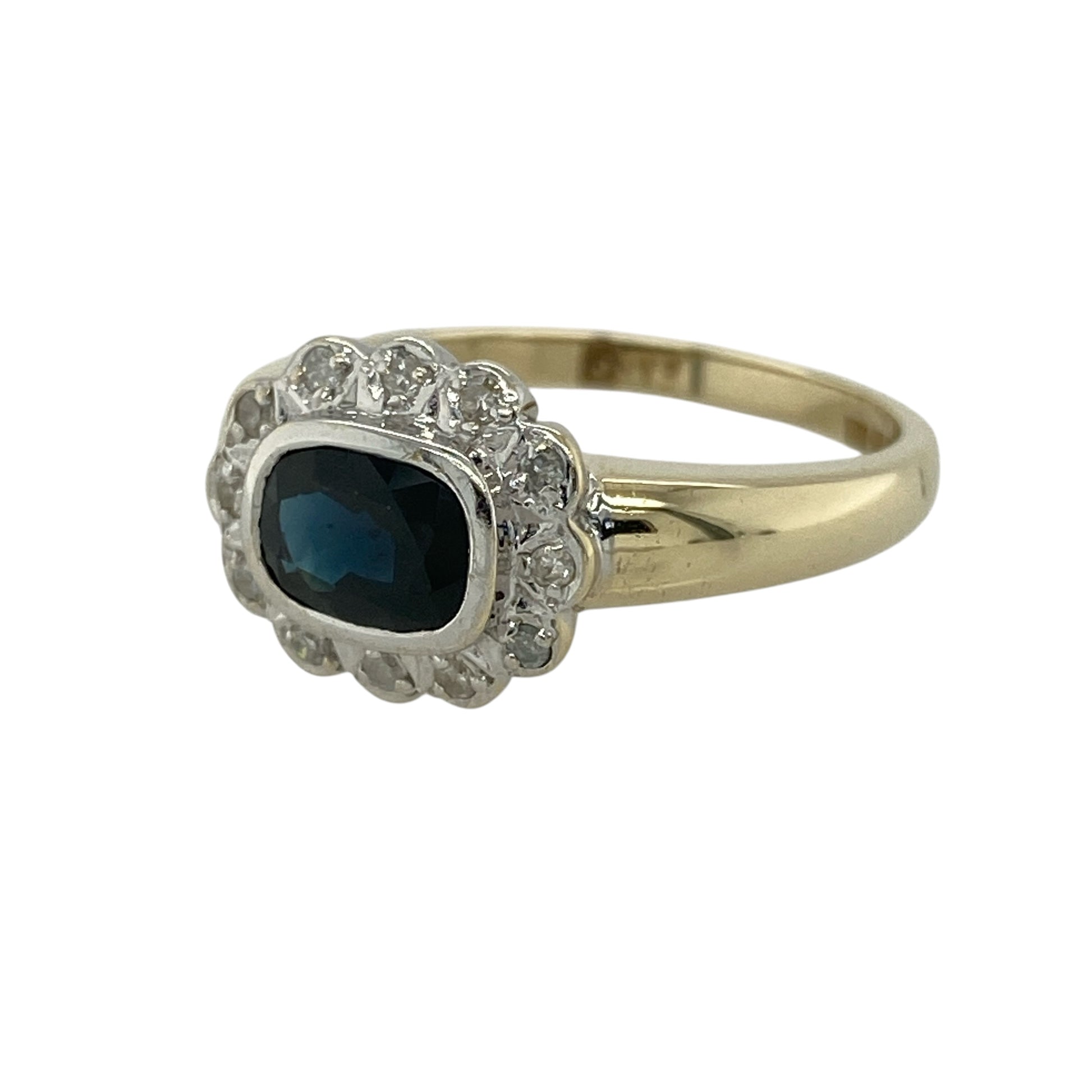 Add elegant colour and timeless sparkle to your jewellery collection with this pre-owned 9ct yellow gold diamond and sapphire cluster ring, featuring a classic design with a striking centre—perfect for special occasions or refined everyday wear.

Design: The ring showcases an oval sapphire measuring approximately 7mm by 5mm at its centre, surrounded by white gold set diamonds that enhance its deep blue tone and create a bright, eye-catching cluster effect.