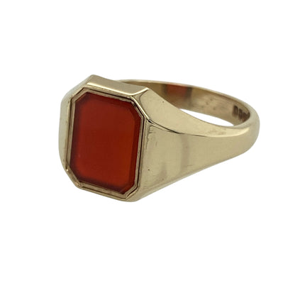 Bring bold vintage character and warm, earthy colour to your collection with this pre-owned 9ct yellow gold carnelian rectangle signet ring—an eye-catching statement piece that blends classic heritage style with everyday wearability.

Design: The ring features a striking 8mm by 10mm rectangular carnelian gemstone, showcasing rich reddish-orange tones that stand out beautifully against the polished gold.