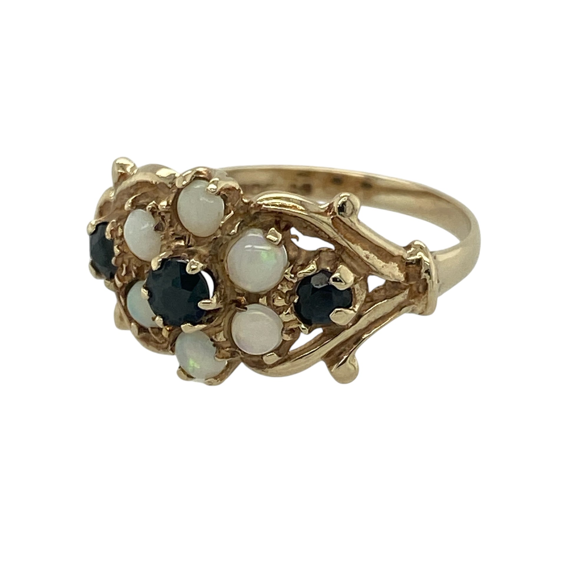 Add vintage charm and soft iridescent colour to your collection with this pre-owned 9ct yellow gold opalique and sapphire set flower ring—an elegant piece with a delicate floral design.

Design: The ring features a flower-inspired cluster measuring approximately 11mm in height, combining opalique stones with sapphire accents to create a beautiful blend of shimmer and rich blue tones.