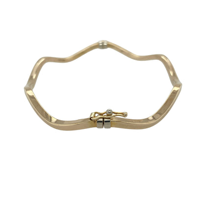Add subtle texture and elegant movement to your collection with this pre-owned 9ct yellow gold wavey bangle—an effortlessly stylish piece perfect for everyday wear.

Design: The bangle features a slim 2mm wide band with a gentle wave pattern, creating a fluid and light-catching finish that adds interest while remaining understated.
Material: Made from 9-carat yellow gold, the polished finish enhances the warmth of the metal and highlights the flowing design.