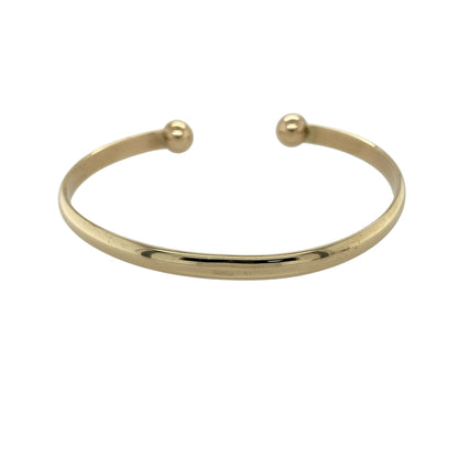 Make a bold and timeless statement with this pre-owned 9ct yellow gold solid torque bangle—an eye-catching piece with classic strength and enduring style.

Design: The bangle features a traditional torque design with a 5mm wide band, offering a clean and structured look with a solid, open-ended form that sits comfortably on the wrist.
Material: Made from 9-carat yellow gold, the polished finish enhances the rich, warm tone of the metal and highlights its smooth, solid construction.