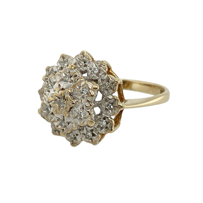 Add elegant sparkle and floral charm to your collection with this pre-owned 9ct yellow gold diamond set flower cluster ring—an eye-catching piece with timeless appeal.

Design: The ring features a flower-inspired cluster head measuring approximately 14mm in height, set with sparkling diamonds that create a bright and intricate floral display.
Material: Made from 9-carat yellow gold, the polished finish enhances the warmth of the metal while complementing the brilliance of the diamonds.