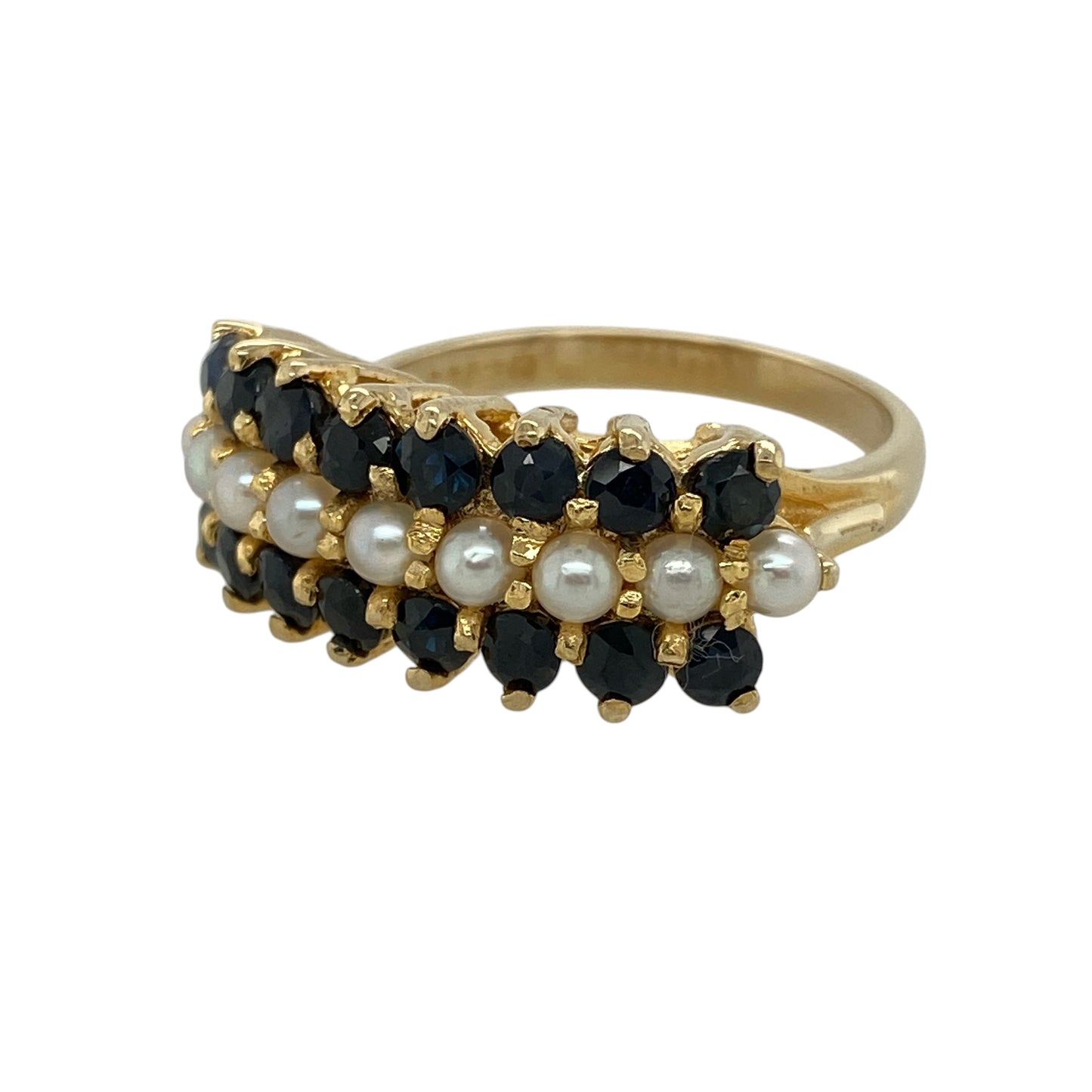 Add classic elegance and refined colour to your collection with this pre-owned 9ct yellow gold sapphire and pearl set band ring—an eye-catching piece with timeless appeal.

Design: The ring features a bold 10mm wide front, beautifully arranged with a central row of lustrous pearls, framed above and below by rows of deep blue sapphires, creating a striking layered effect.
