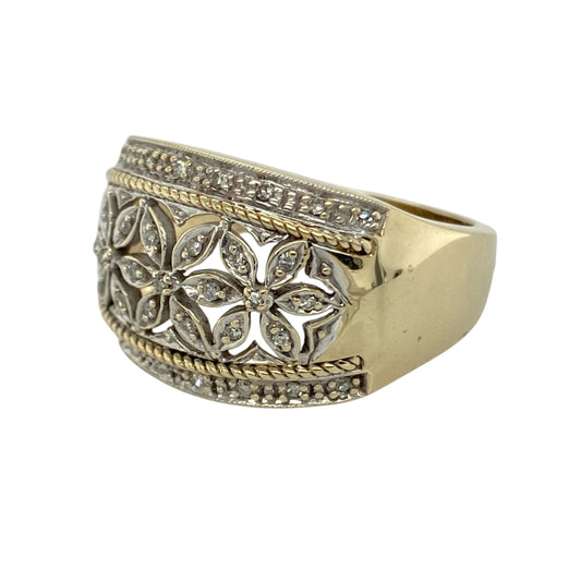Make a bold and elegant statement with this pre-owned 9ct yellow and white gold diamond set flower patterned wide band ring—an eye-catching piece with timeless appeal.

Design: The ring features an impressive wide band front measuring approximately 19mm in height, adorned with a floral patterned design and set with sparkling diamonds that add brilliance and detail.
Material: Made from 9-carat yellow and white gold, the two-tone finish enhances the intricate pattern while adding contrast and visual interest.