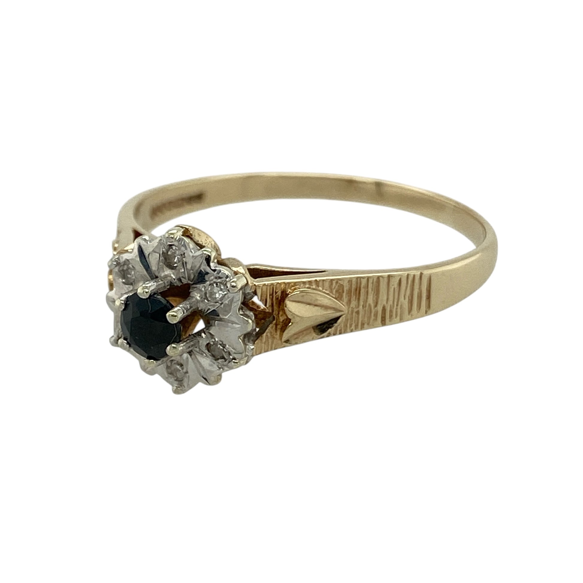 Add elegant colour and timeless sparkle to your collection with this pre-owned 9ct yellow and white gold diamond and sapphire set cluster ring—an eye-catching piece with classic appeal.

Design: The ring features a 4mm round sapphire at the centre, surrounded by a cluster of sparkling diamonds that enhance its deep blue tone and create a bright, refined focal point.