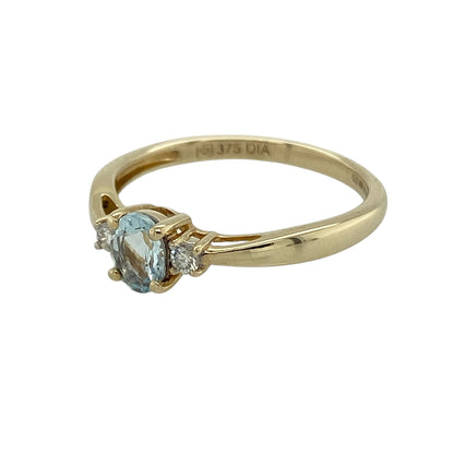 Bring soft colour and classic elegance to your collection with this pre-owned 9ct yellow gold diamond and blue stone trilogy ring, featuring a delicate design with subtle sparkle—perfect for everyday wear or a meaningful gift.

Design: The ring showcases a 5mm by 4mm oval aqua-coloured stone at the centre, flanked by a small diamond on either side, creating a balanced and timeless trilogy style.
Material: Made from 9-carat yellow gold