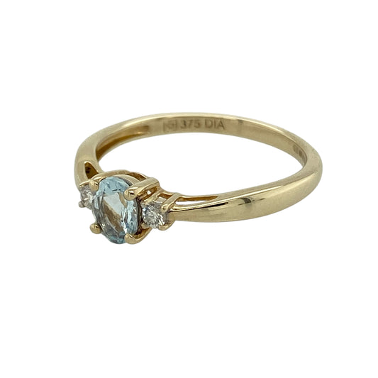 Bring soft colour and classic elegance to your collection with this pre-owned 9ct yellow gold diamond and blue stone trilogy ring, featuring a delicate design with subtle sparkle—perfect for everyday wear or a meaningful gift.

Design: The ring showcases a 5mm by 4mm oval aqua-coloured stone at the centre, flanked by a small diamond on either side, creating a balanced and timeless trilogy style.
Material: Made from 9-carat yellow gold