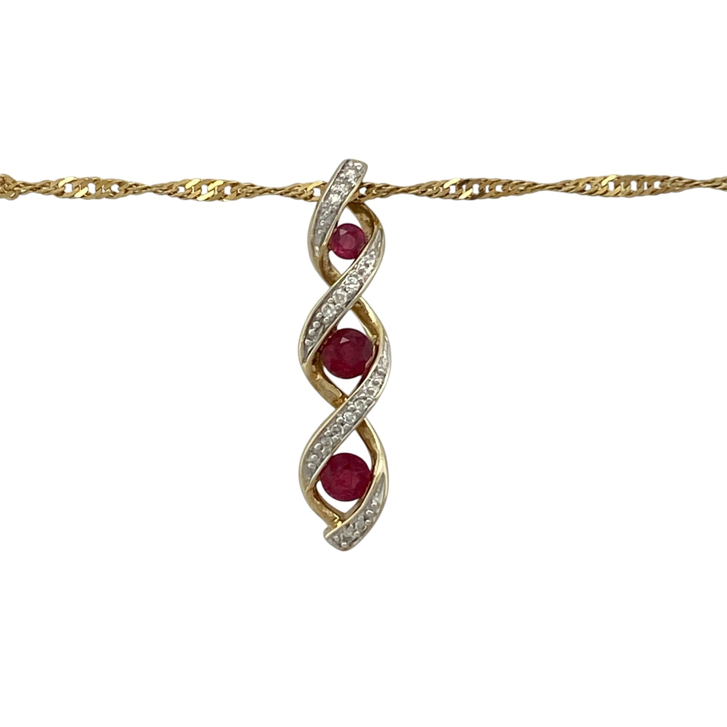 Bring elegant movement and rich colour to your collection with this pre-owned 9ct yellow and white gold diamond and ruby set twisted pendant necklace, featuring a graceful design with vibrant detail—perfect for both everyday wear and special occasions.

Design: The pendant features a twisted design measuring approximately 2.7cm in length, set with three rubies and accented with sparkling diamonds, creating a flowing and eye-catching look.