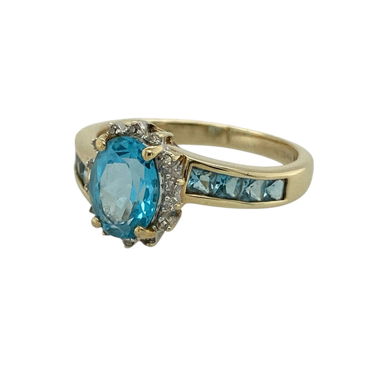 Bring vibrant colour and elegant sparkle to your collection with this pre-owned 9ct yellow gold diamond and blue topaz cluster ring, featuring a striking centre stone and refined detail—perfect for special occasions or standout everyday wear.

Design: The ring showcases an 8mm by 6mm oval blue topaz at the centre, surrounded by sparkling diamonds, with additional blue topaz stones set along the shoulders for added colour and brilliance.