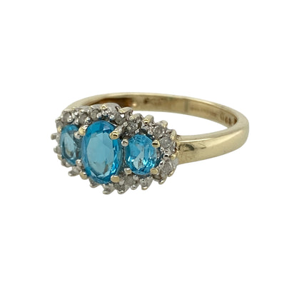 Bring vibrant colour and elegant sparkle to your collection with this pre-owned 9ct yellow gold diamond and blue topaz trilogy cluster ring, featuring a timeless design with refined detail—perfect for everyday wear or special occasions.

Design: The ring showcases a trilogy-style cluster arrangement centred around a 6mm by 4mm blue topaz, accented with sparkling diamonds that enhance the brilliance and create a balanced, eye-catching look.