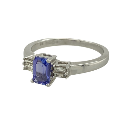 Bring elegant colour and refined sparkle to your collection with this pre-owned 9ct white gold diamond and tanzanite ring, featuring a sophisticated design with timeless appeal—perfect for special occasions or everyday luxury.

Design: The ring showcases a 6mm by 4mm rectangular tanzanite at the centre, accented by two baguette cut diamonds on either side for a balanced and elegant finish.