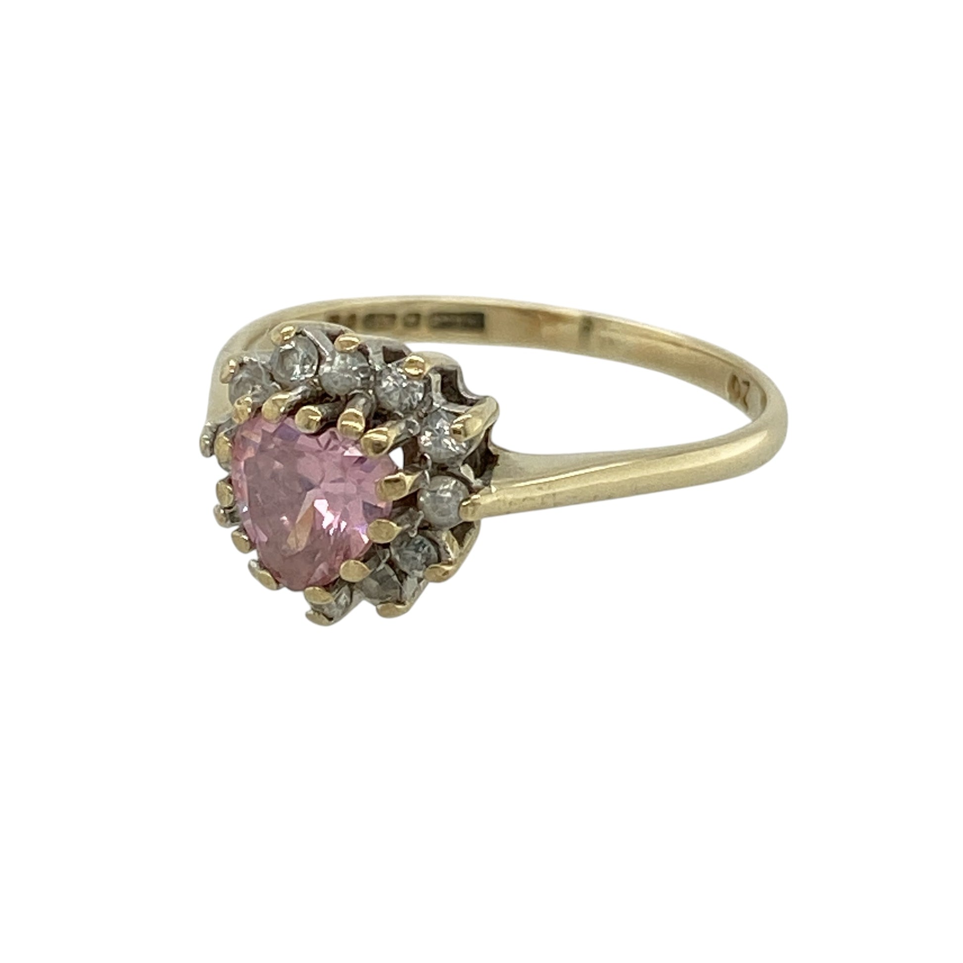 Bring romantic charm and delicate sparkle to your collection with this pre-owned 9ct yellow gold pink stone and cubic zirconia heart cluster ring, featuring a feminine design with timeless appeal—perfect for everyday wear or a thoughtful gift.

Design: The ring showcases a 5mm heart-shaped pink stone at the centre, surrounded by sparkling cubic zirconia in a classic cluster arrangement for an elegant and eye-catching finish.