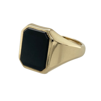 Add bold vintage-inspired style to your jewellery collection with this pre-owned 9ct yellow gold onyx set signet ring, featuring a striking rectangular black onyx stone with timeless statement appeal—perfect for everyday wear, formal occasions, or classic jewellery styling.

Design: The ring showcases a polished rectangular onyx stone measuring approximately 13mm by 10mm, creating a bold and eye-catching focal point within the traditional signet ring design.