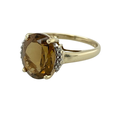 Add vibrant colour and elegant sparkle to your jewellery collection with this pre-owned 9ct yellow gold diamond and yellow stone ring, featuring a striking oval-cut centre stone with timeless appeal—perfect for occasion wear, gifting, or adding a bold touch to everyday styling.

Design: The ring showcases a large oval yellow stone measuring approximately 11mm by 9mm, complemented by delicate diamond accents that enhance the brilliance and create an eye-catching, elegant look.