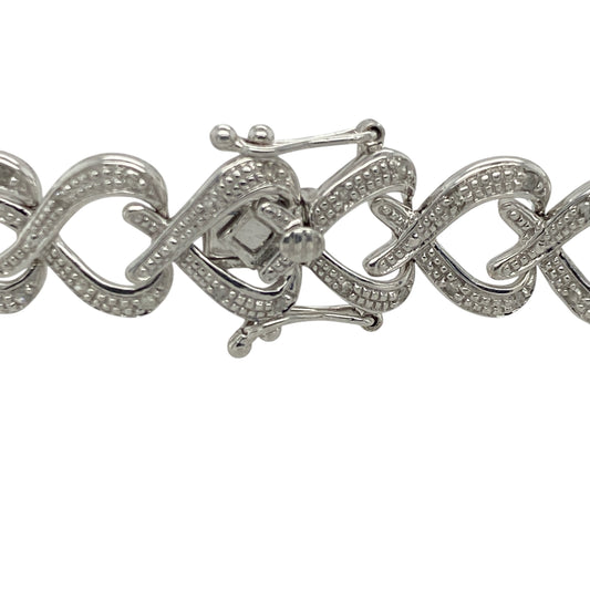 Add romantic elegance and luxurious sparkle to your jewellery collection with this pre-owned 9ct white gold diamond heart link bracelet, featuring a bold statement design with timeless feminine appeal—perfect for special occasions, gifting, or sophisticated everyday wear.

Design: The bracelet features beautifully detailed heart-shaped links accented with sparkling diamonds, creating an eye-catching and elegant design with timeless charm.