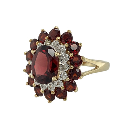 Add rich colour and timeless elegance to your jewellery collection with this pre-owned 9ct yellow gold diamond and garnet cluster ring, featuring a striking multi-gemstone design with luxurious vintage-inspired appeal—perfect for special occasions, gifting, or statement everyday wear.

Design: The ring showcases a beautiful oval garnet centre stone measuring approximately 9mm by 7mm