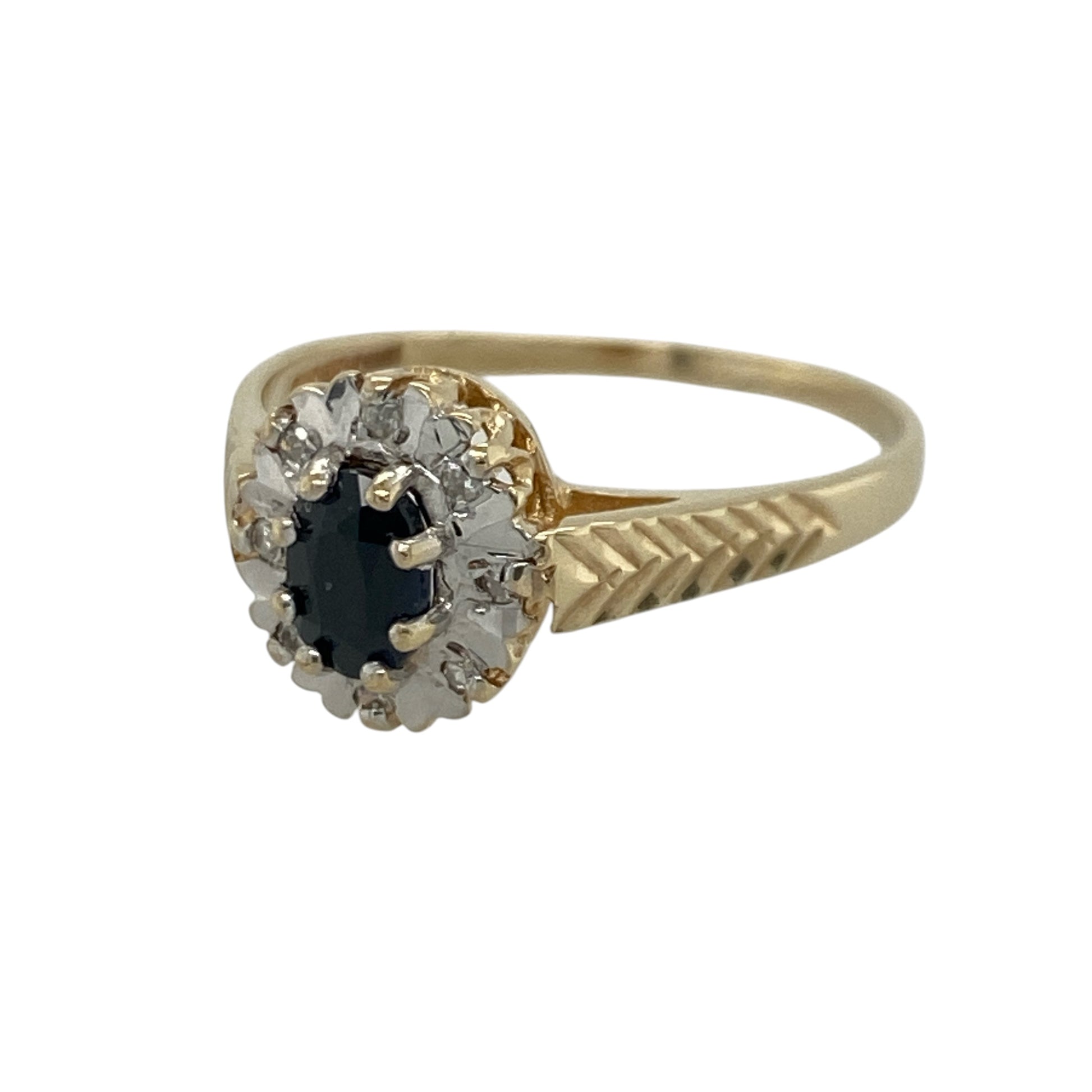 Add timeless elegance and rich colour to your jewellery collection with this pre-owned 9ct yellow gold diamond and sapphire cluster ring, featuring a classic gemstone design with beautifully detailed shoulders and refined sparkle—perfect for special occasions, gifting, or sophisticated everyday wear.

Design: The ring showcases a beautiful oval sapphire centre stone measuring approximately 6mm by 4mm, surrounded by sparkling diamonds in an elegant cluster setting.