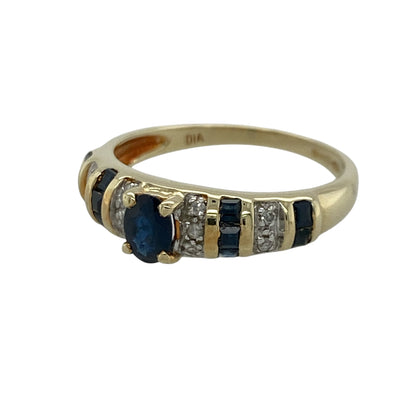 Add timeless elegance and rich colour to your jewellery collection with this pre-owned 14ct yellow gold diamond and sapphire band ring, featuring a classic gemstone design with refined sparkle and everyday sophistication—perfect for special occasions, gifting, or elegant daily wear.

Design: The ring showcases a beautiful oval sapphire centre stone measuring approximately 5mm by 4mm, complemented by additional sapphires and sparkling diamonds set along the band.