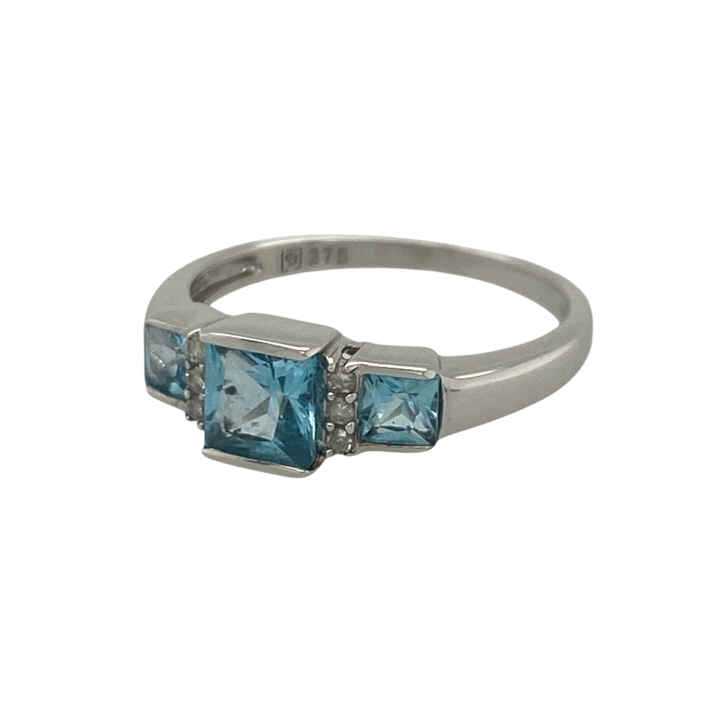Add elegant colour and timeless sparkle to your jewellery collection with this pre-owned 9ct white gold diamond and blue topaz trilogy ring, featuring a sophisticated multi-stone design with refined everyday appeal—perfect for special occasions, gifting, or stylish daily wear.

Design: The ring showcases a beautiful rectangular blue topaz centre stone measuring approximately 5mm by 3mm, flanked by smaller blue topaz stones on either side.
