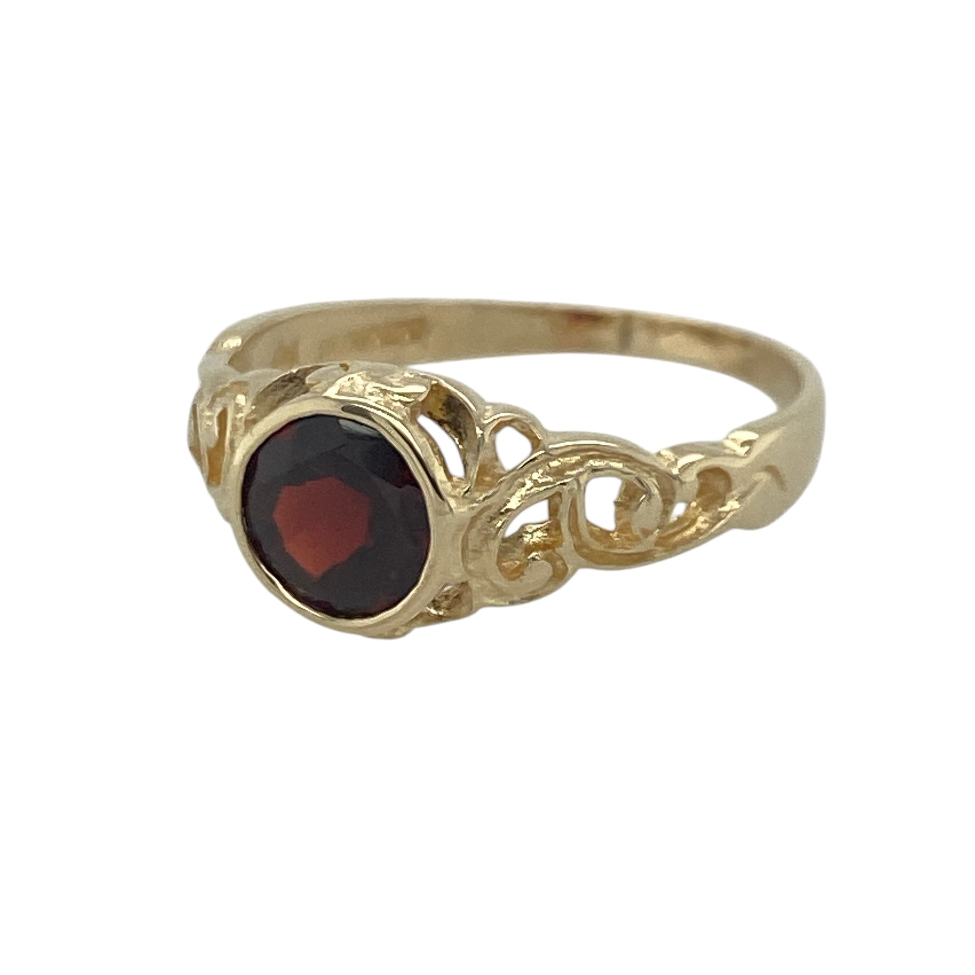 Add rich colour and vintage-inspired elegance to your jewellery collection with this pre-owned 9ct yellow gold garnet ring, featuring decorative open patterned shoulders and timeless gemstone appeal—perfect for special occasions, gifting, or refined everyday wear.

Design: The ring showcases a beautiful round garnet measuring approximately 6mm in diameter, creating a striking focal point with its deep red colour. 