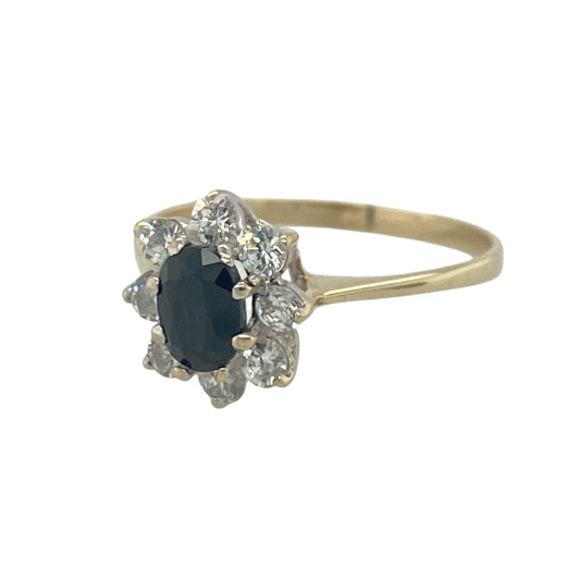 Add timeless elegance and rich colour to your jewellery collection with this pre-owned 9ct yellow gold sapphire and cubic zirconia cluster ring, featuring a classic gemstone design with refined everyday appeal—perfect for special occasions, gifting, or sophisticated daily wear.

Design: The ring showcases a beautiful oval sapphire measuring approximately 6mm by 4mm, surrounded by sparkling cubic zirconia stones in an elegant cluster setting.