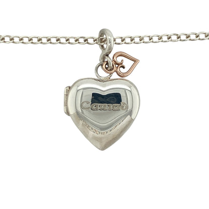 Bring sentimental elegance and romantic charm to your collection with this pre-owned Clogau Cariad heart locket pendant in silver and 9ct rose gold, suspended on an 18-inch curb chain—a timeless piece symbolising love and keepsake memories.

Design: The pendant measures 3.5cm long including the bail, with a heart-shaped locket space approximately 18mm by 18mm, offering room for cherished photos or mementos. Engraved with “Cariad,” the Welsh word for “Love,” it carries a meaningful and personal touch.