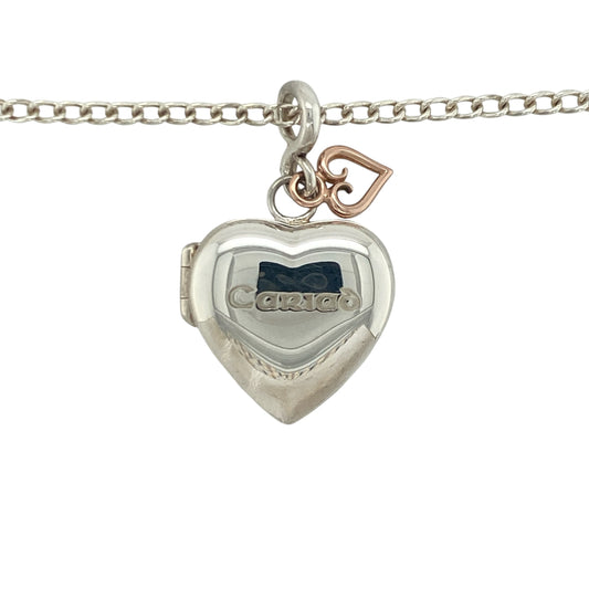 Bring sentimental elegance and romantic charm to your collection with this pre-owned Clogau Cariad heart locket pendant in silver and 9ct rose gold, suspended on an 18-inch curb chain—a timeless piece symbolising love and keepsake memories.

Design: The pendant measures 3.5cm long including the bail, with a heart-shaped locket space approximately 18mm by 18mm, offering room for cherished photos or mementos. Engraved with “Cariad,” the Welsh word for “Love,” it carries a meaningful and personal touch.