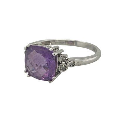 Add a touch of vibrant colour and elegant sparkle to your jewellery collection with this pre-owned 9ct white gold diamond and amethyst ring, featuring a striking gemstone design with timeless appeal—perfect for special occasions, gifting, or sophisticated everyday wear.

Design: The ring showcases a beautiful cushion-cut amethyst measuring approximately 8mm by 8mm, creating a bold and eye-catching focal point with its rich purple hue.