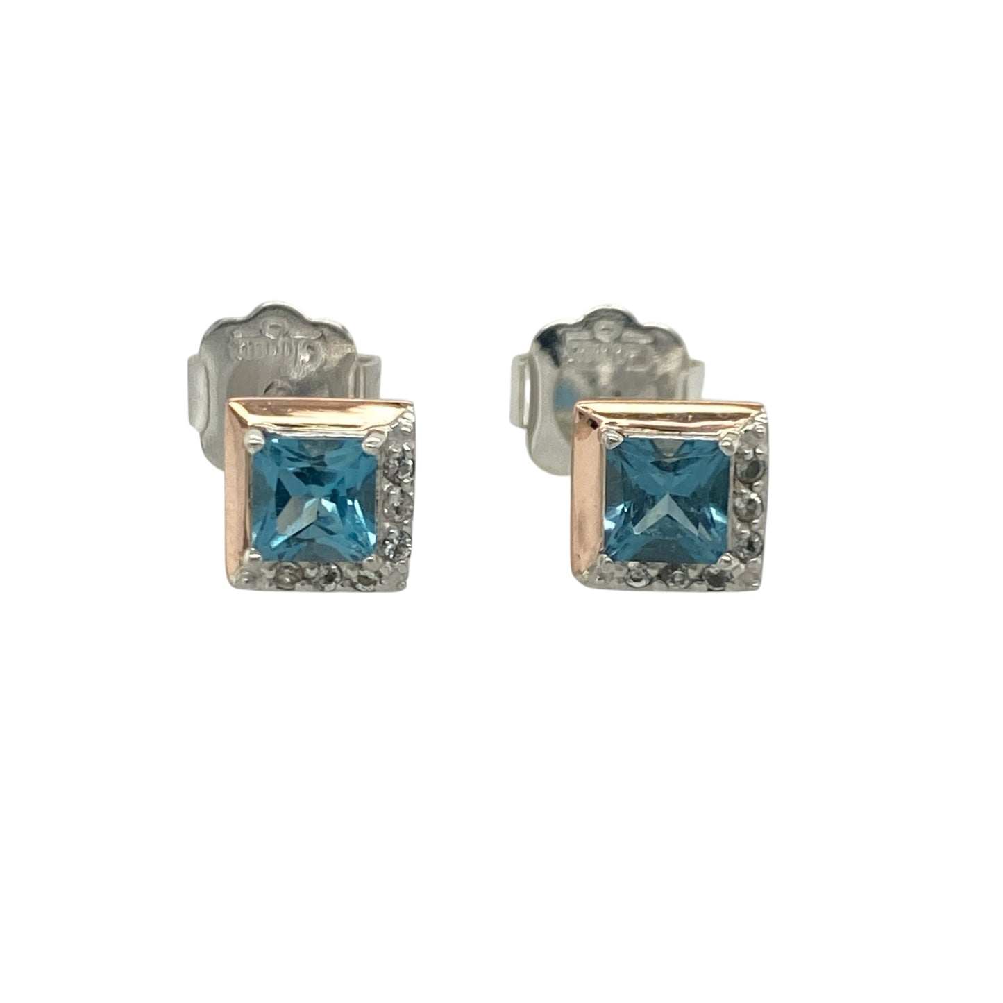 Add a touch of Welsh-inspired romance and elegant sparkle to your jewellery collection with these pre-owned sterling silver, 9ct rose gold, blue topaz and white topaz Clogau Kensington Love Story stud earrings, featuring a beautifully crafted design with timeless appeal—perfect for gifting, special occasions, or refined everyday wear.

Design: The earrings showcase a sophisticated square design set with vibrant blue topaz gemstones measuring approximately 4mm by 4mm.
