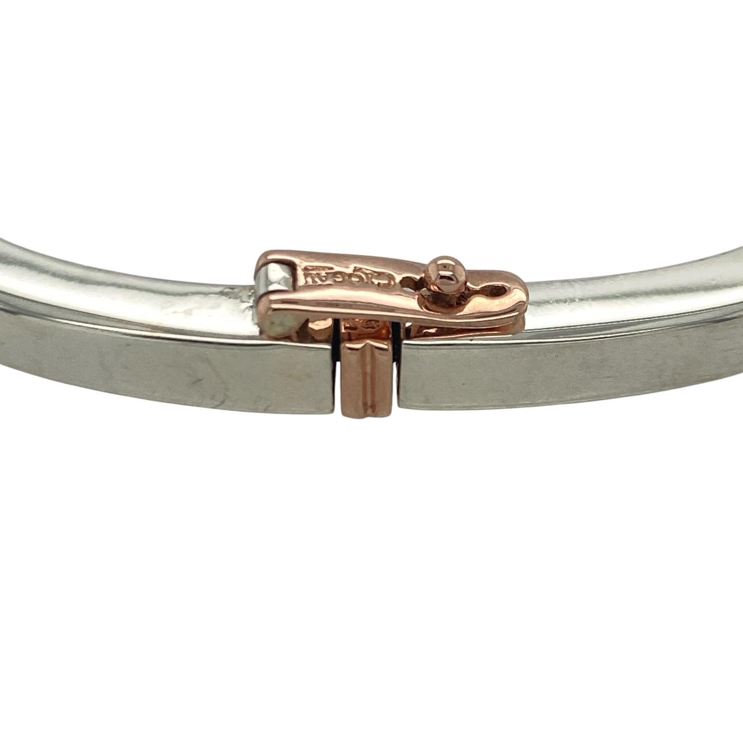 Bring meaningful elegance and bold design to your collection with this pre-owned Clogau solid square bangle in silver and 9ct rose gold, engraved with “Cariad”—the Welsh word for “Love.”

Design: The bangle features a square profile with a 4mm width, accented with 9ct rose gold and engraved with “Cariad” on one corner for a personal and symbolic touch.
Material: Made from 925 sterling silver with 9-carat rose gold, the polished surface enhances the two-tone detail and inscription.