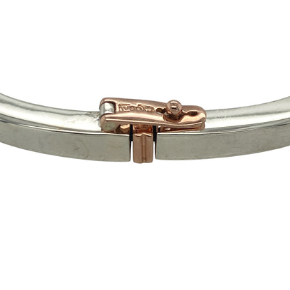 Bring meaningful elegance and bold design to your collection with this pre-owned Clogau solid square bangle in silver and 9ct rose gold, engraved with “Cariad”—the Welsh word for “Love.”

Design: The bangle features a square profile with a 4mm width, accented with 9ct rose gold and engraved with “Cariad” on one corner for a personal and symbolic touch.
Material: Made from 925 sterling silver with 9-carat rose gold, the polished surface enhances the two-tone detail and inscription.