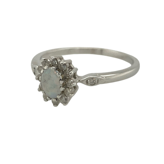 Add a touch of iridescent beauty and timeless sparkle to your jewellery collection with this pre-owned 9ct white gold diamond and opalique cluster ring, featuring an elegant gemstone design with refined everyday appeal—perfect for special occasions, gifting, or sophisticated daily wear.

Design: The ring showcases a beautiful oval opalique centre stone measuring approximately 6mm by 4mm, displaying soft flashes of colour and a captivating iridescent appearance.